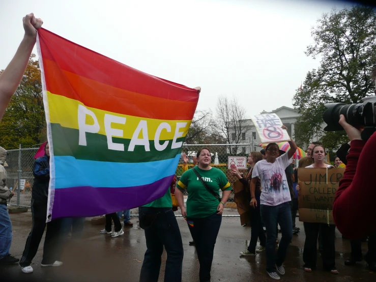 a group of people with some protesting in front of a fence