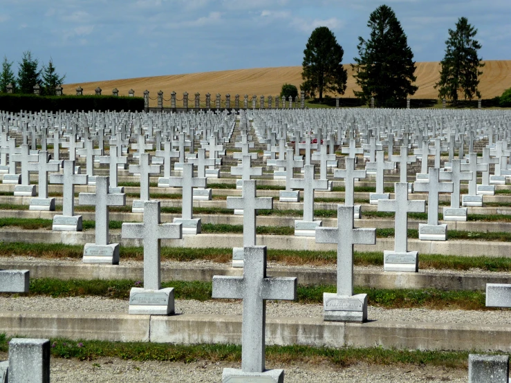 many headstones in large rows at a cemetery