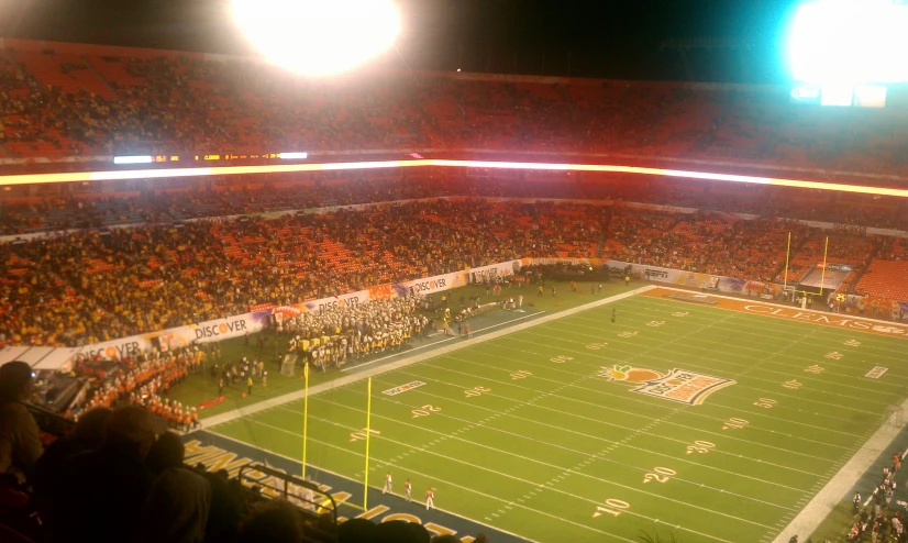 an empty football stadium filled with people and some lights