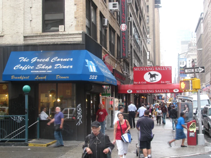 pedestrians walking down the sidewalk past a business