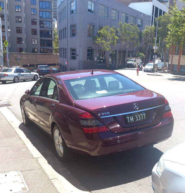 a maroon car parked on the side of a street