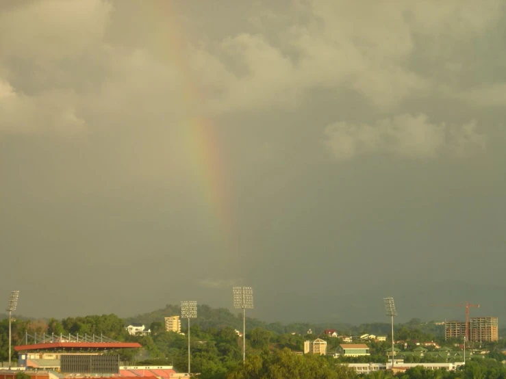 the rainbow appears in the dark cloud over a city