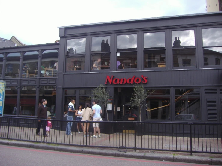 many people standing outside the window of a restaurant
