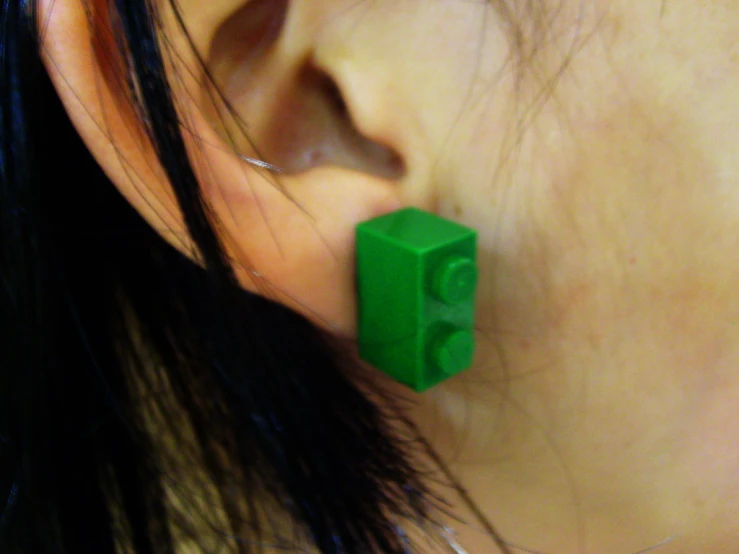 the top view of a woman wearing green plastic ear clips