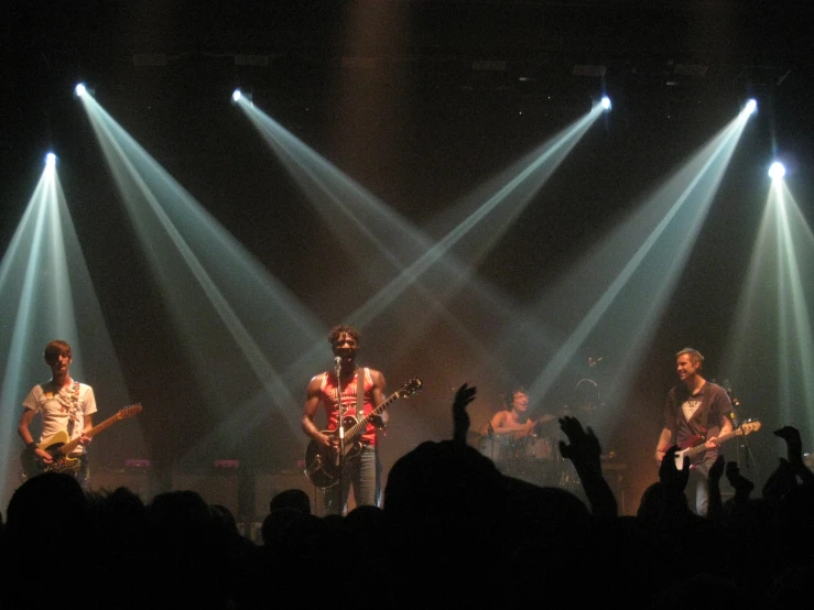 the group is playing in front of a large crowd