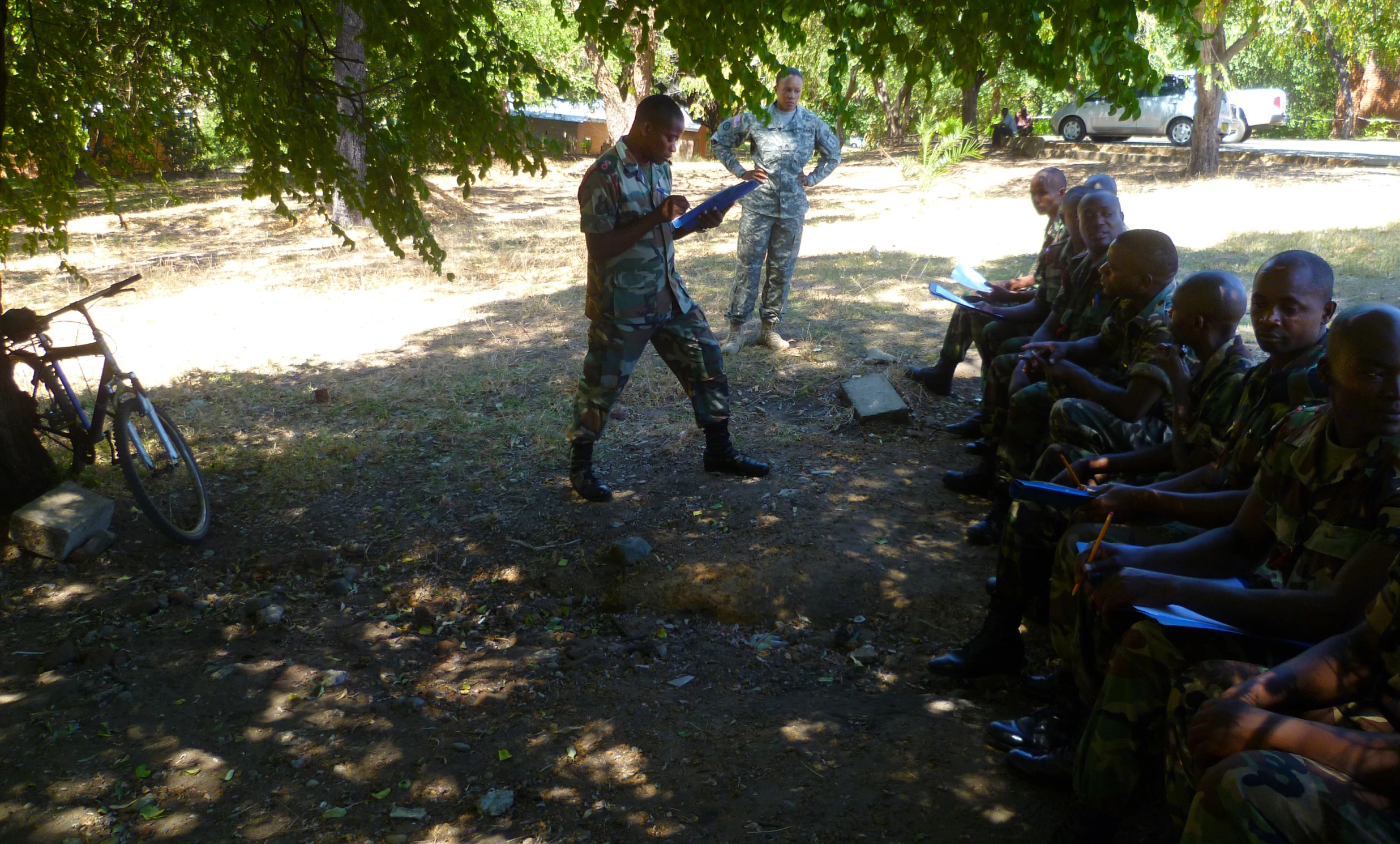 a man in a camouflage uniform talking to soldiers