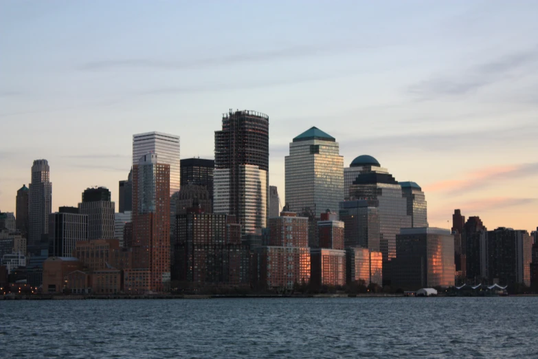 large tall buildings in city next to river with boat