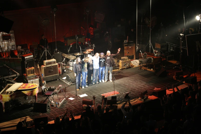 group of people standing on stage in the dark