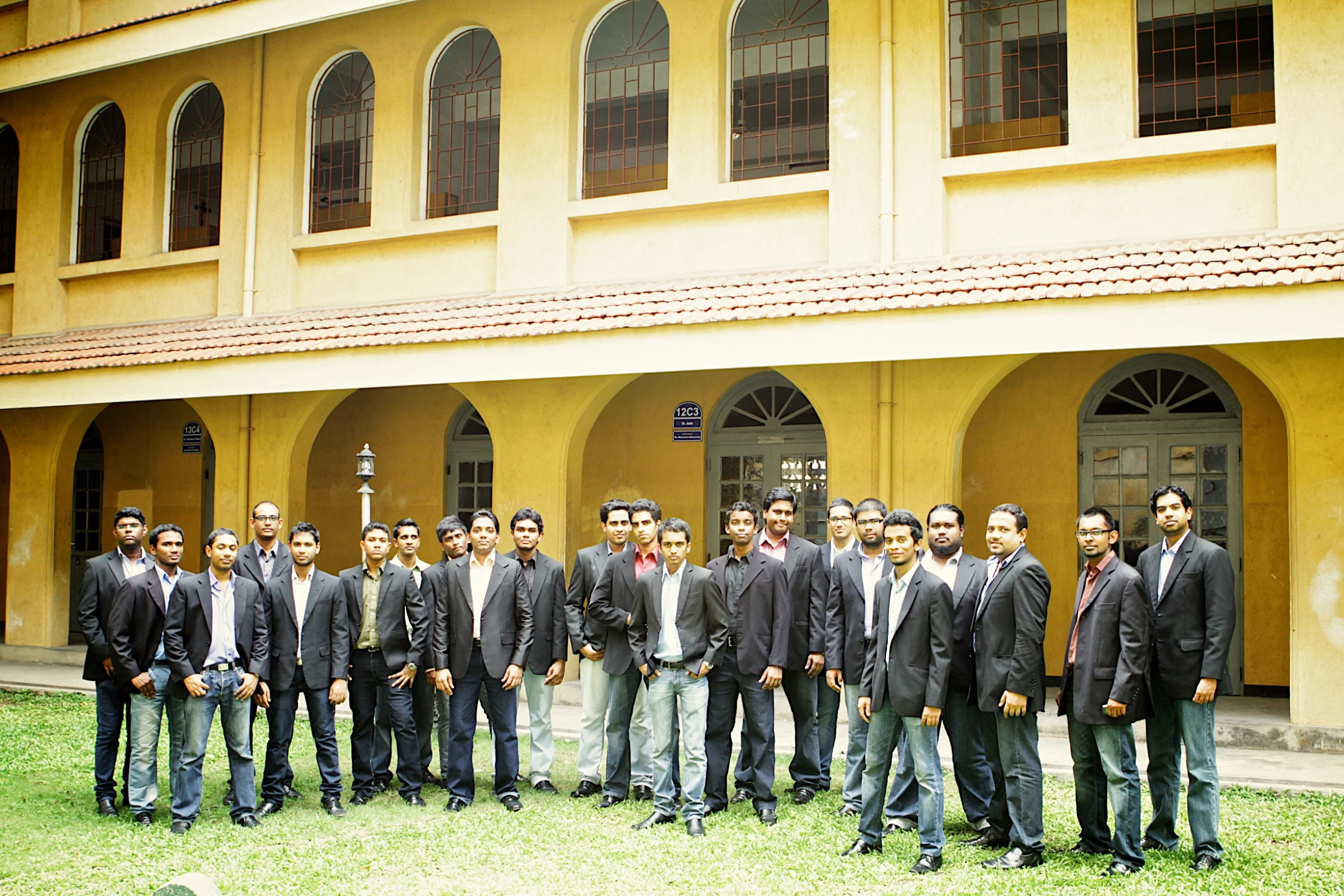 a group of men in suits standing in front of a building