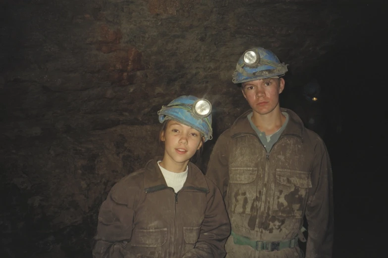 two people are wearing hats in a cave
