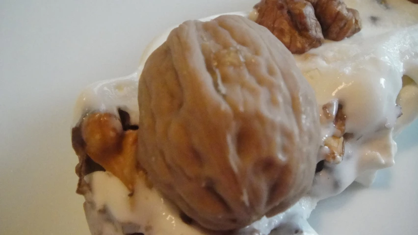 an ice cream with nuts, cream and a spoon