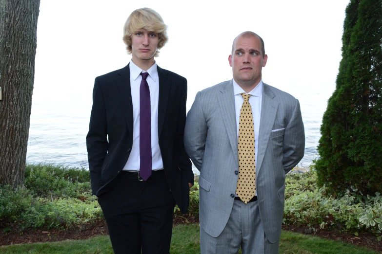 two men are standing next to each other, in suits and ties