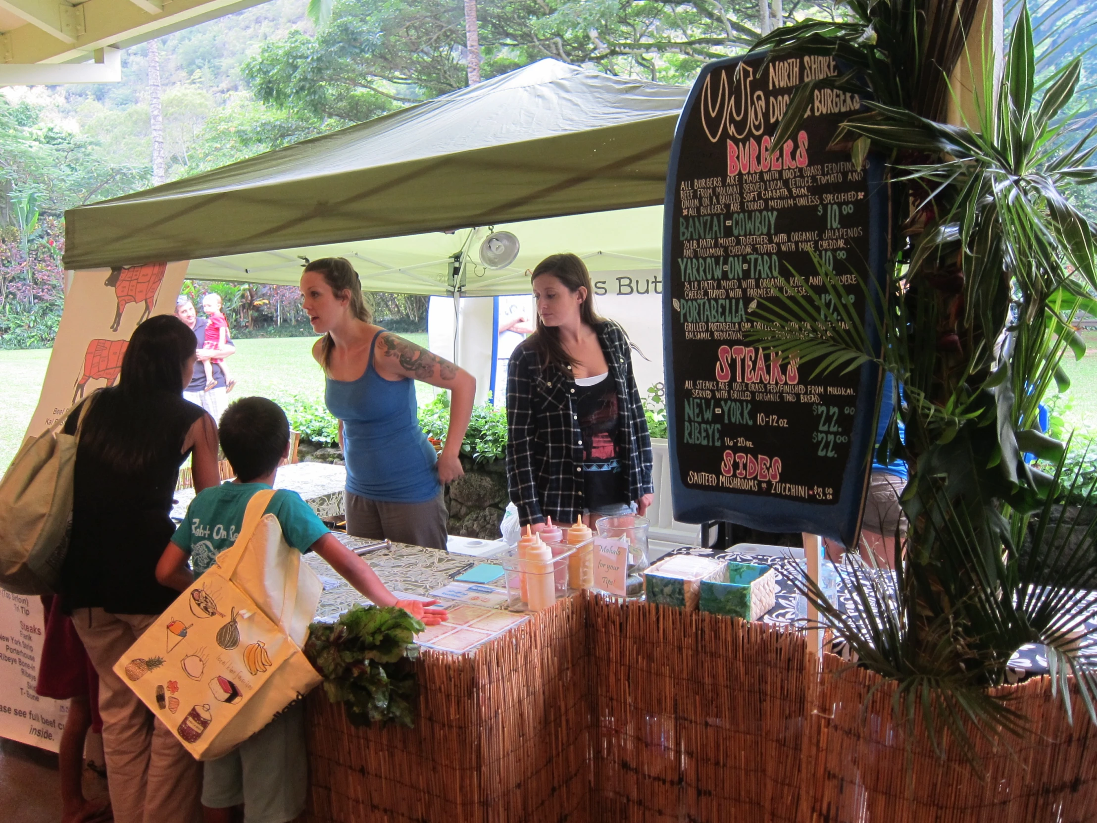 a group of people are buying food from a stall