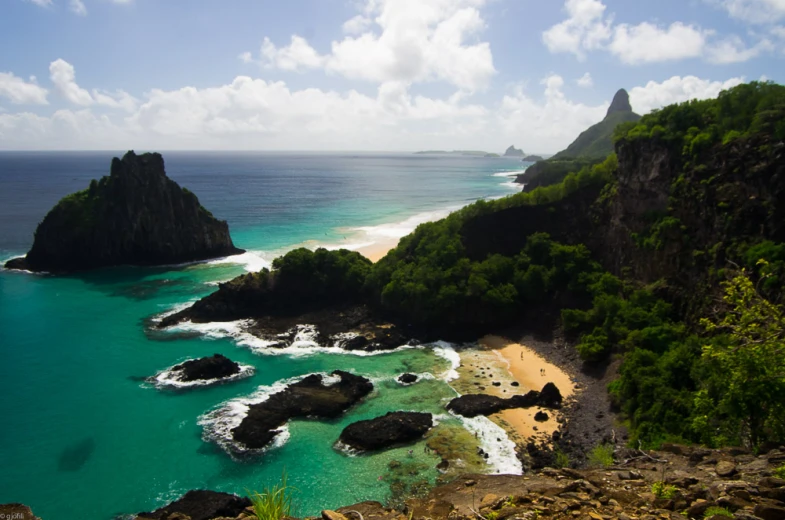 a view of the shore with a turquoise sea next to two island