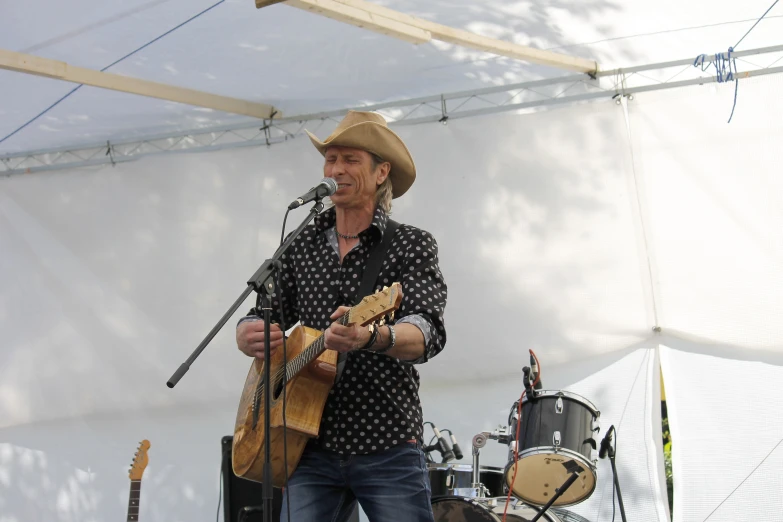 a man that is holding a guitar in hand