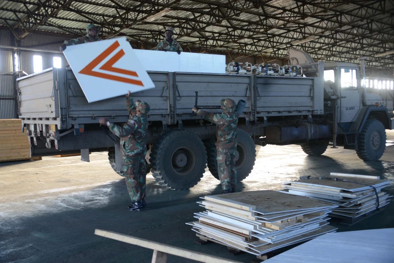 men in camouflage clothes standing beside a large truck