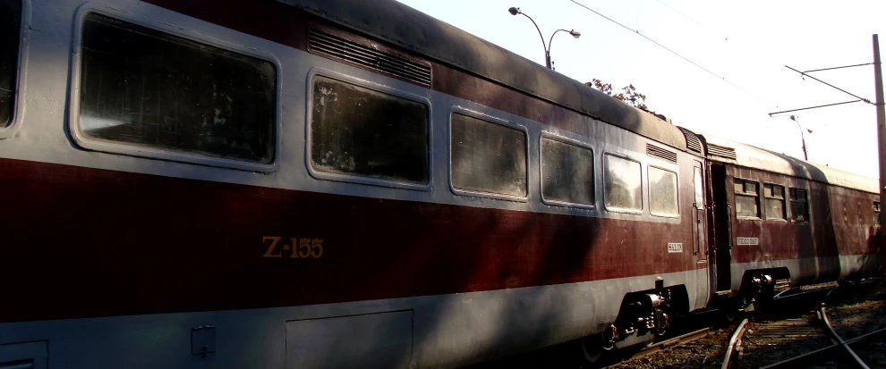 the front of a red and silver train traveling down tracks