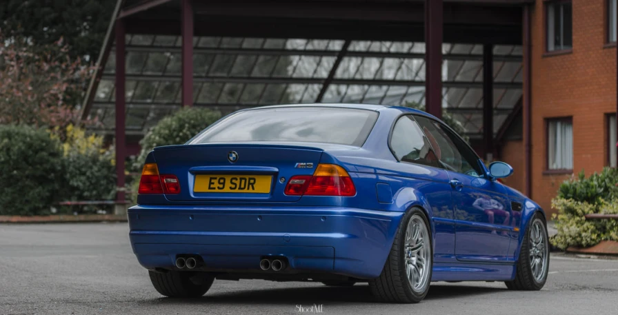 a blue bmw parked on the side of a street