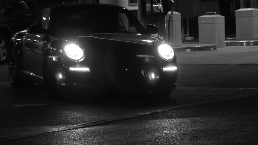 a black and white pograph of the headlights on a small car