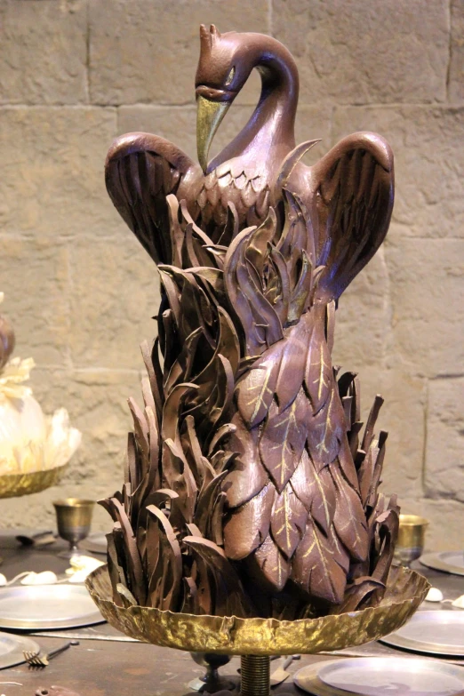 a fountain made from bronze leafy birds on a gold plated stand