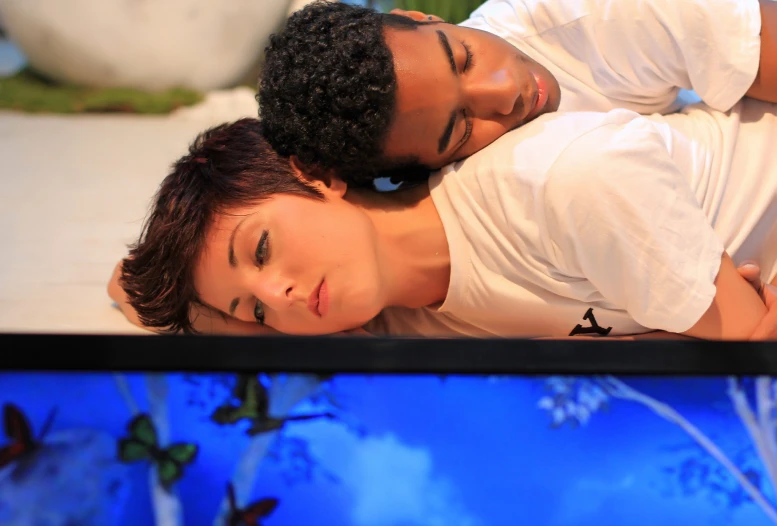 a man and woman lay on the back of a bed