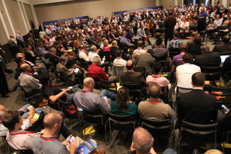 a large audience sits at different stages of a presentation