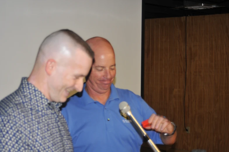 a couple of men standing next to each other with microphone