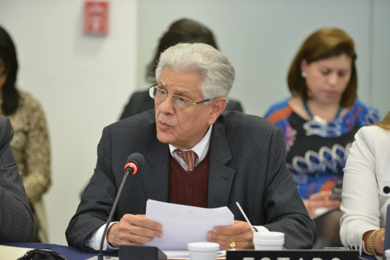 a man is speaking into a microphone at a meeting