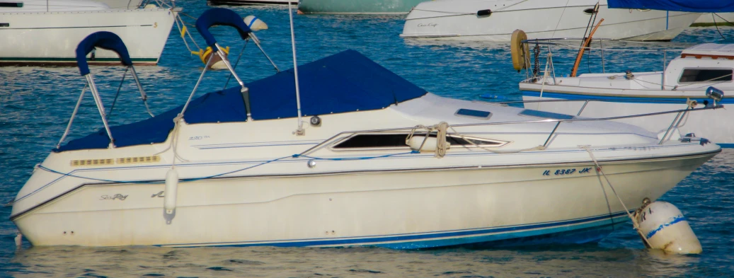 several white boats parked in a blue, rippled marina