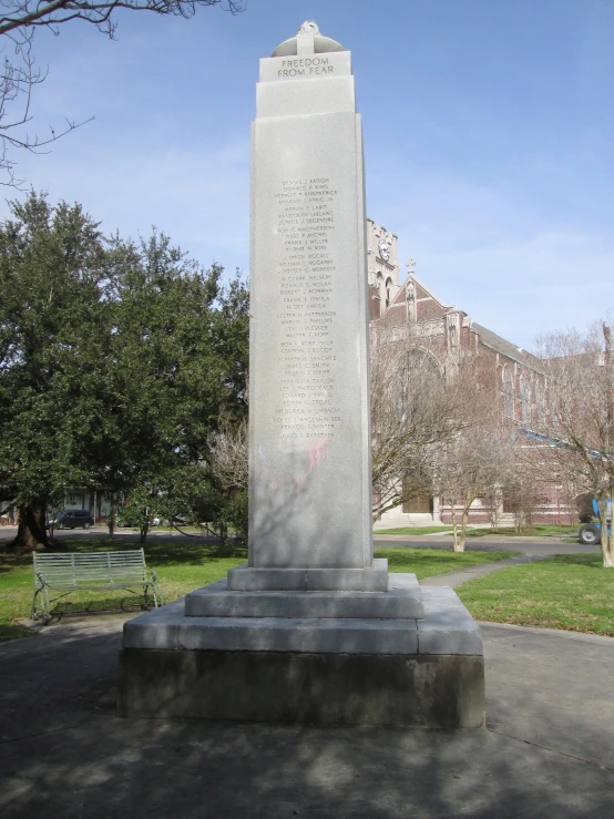 a monument in a park with benches and trees