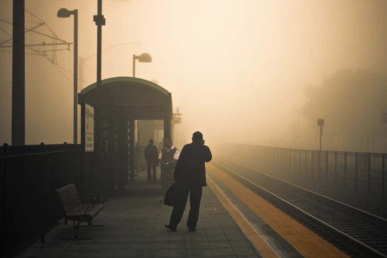 a person standing on train tracks in fog