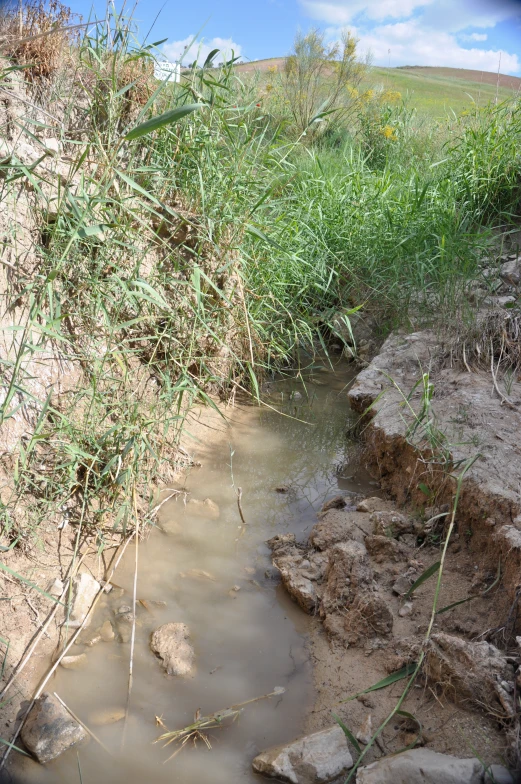 a stream flowing off of side of a hillside