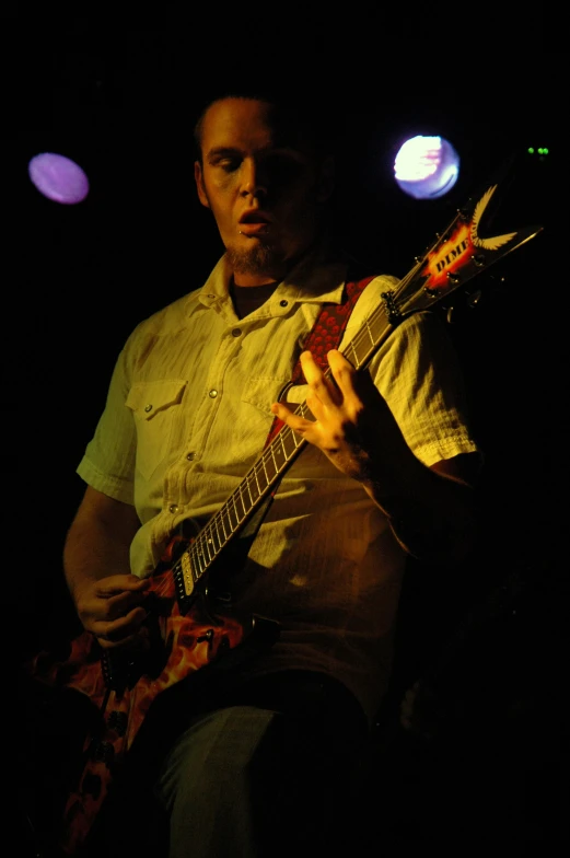 a man with a tie plays his electric guitar
