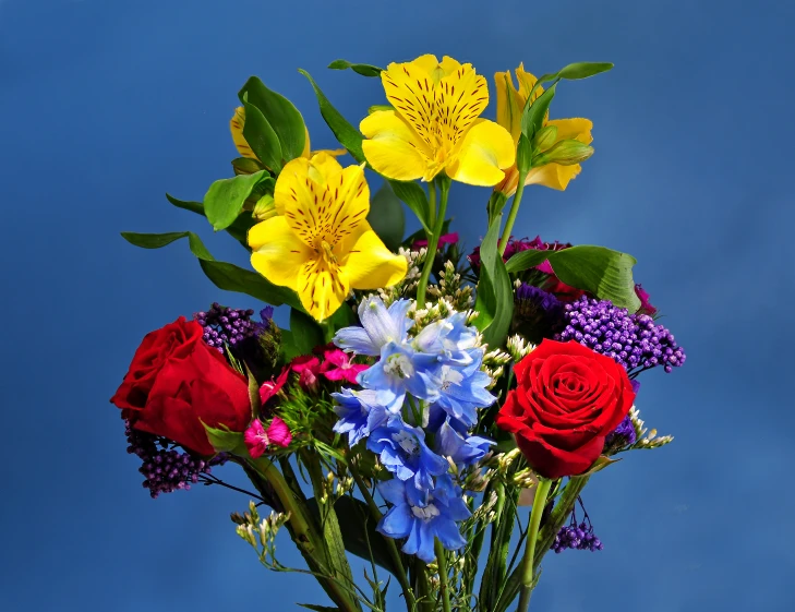 an arrangement of wildflowers, tulips and roses