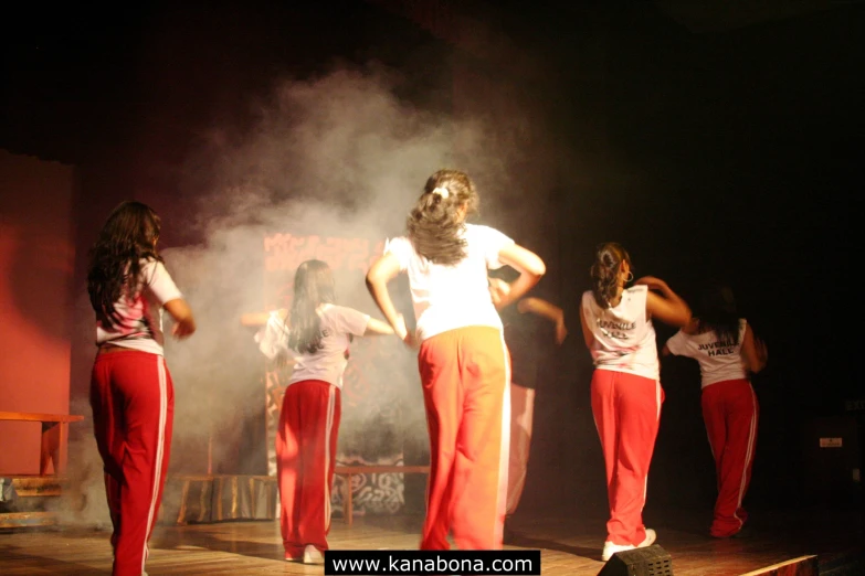 four dancers standing in a line on a stage