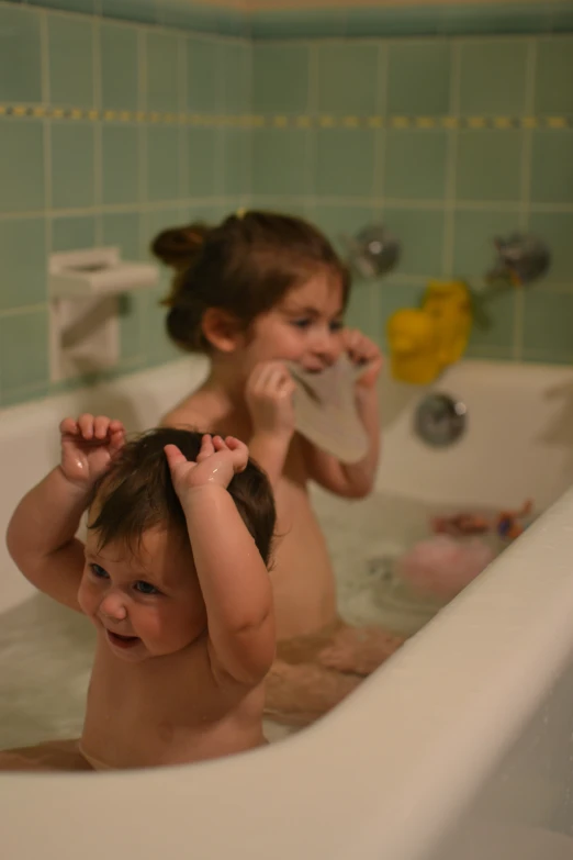 two little children standing in a bath tub