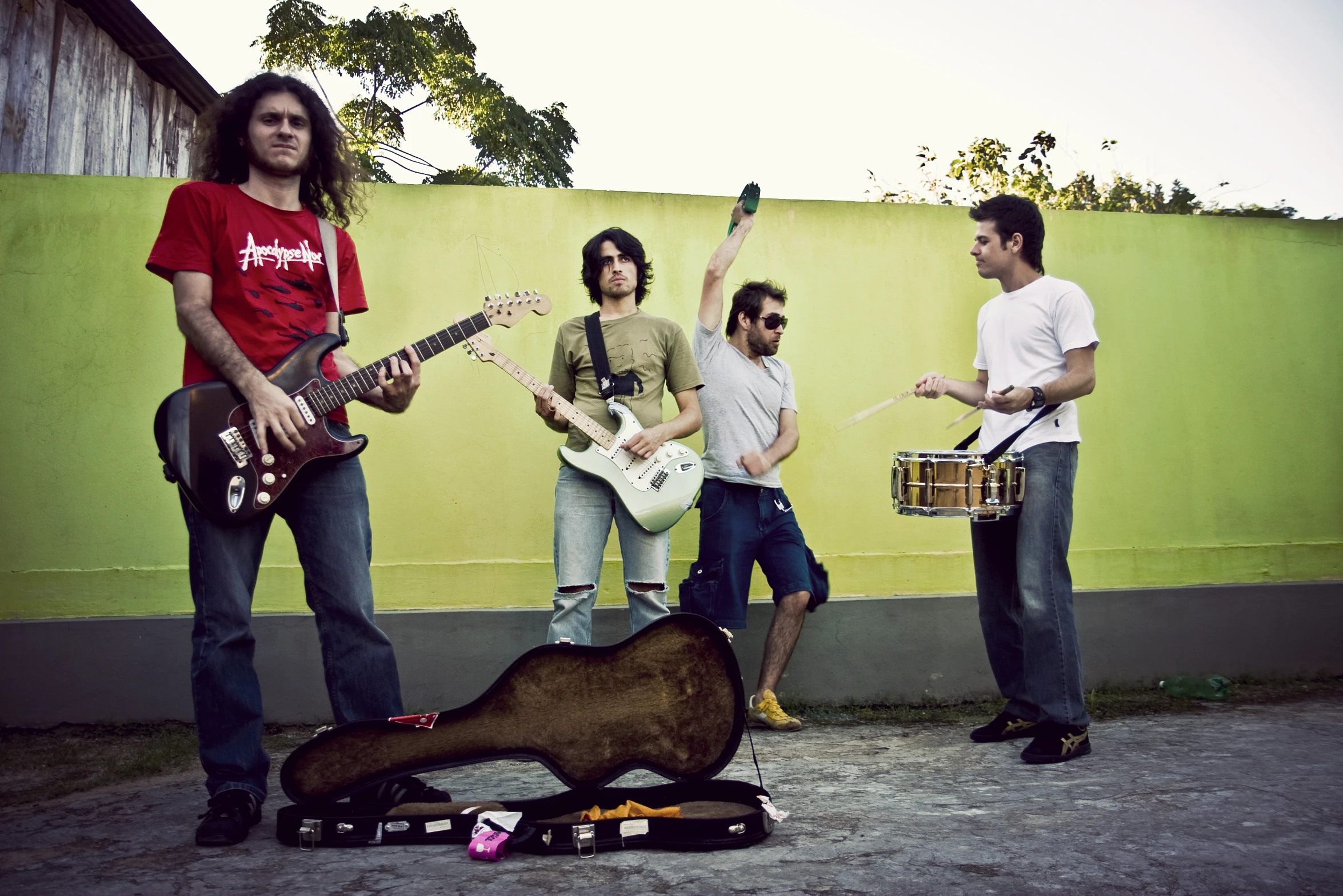 three men are playing guitar while two women stand with their guitars