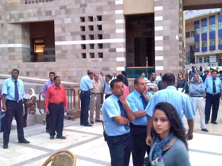 a group of people in blue shirts outside a building