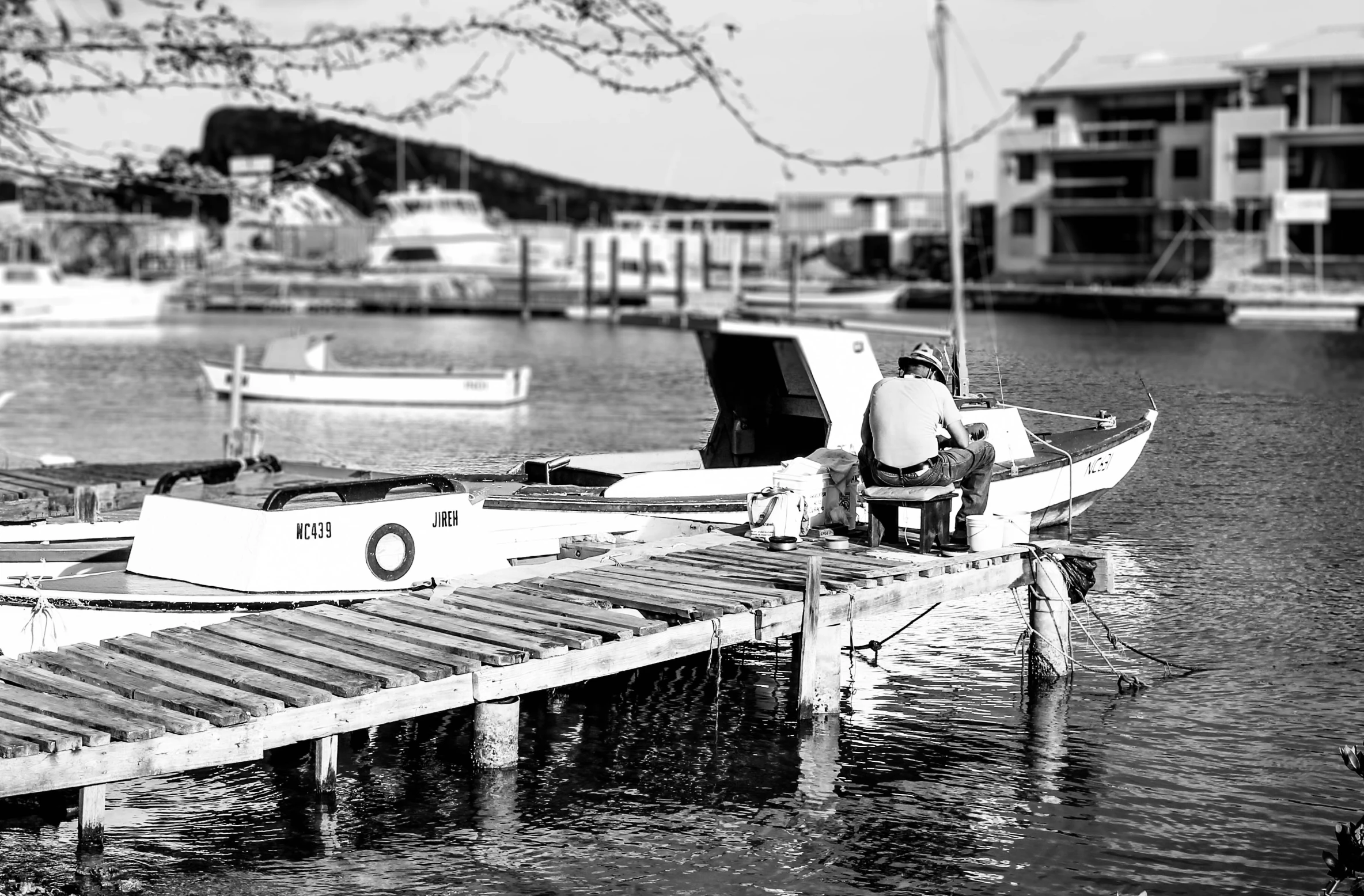 a small white boat sits docked next to a bridge