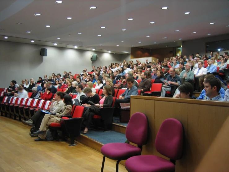 people sitting in front of a podium listening to an audience