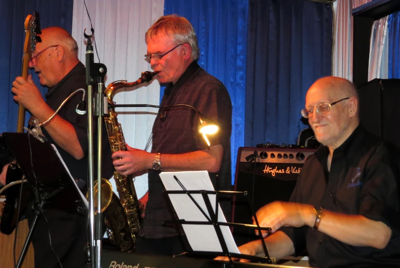 two men with instruments are playing at a band