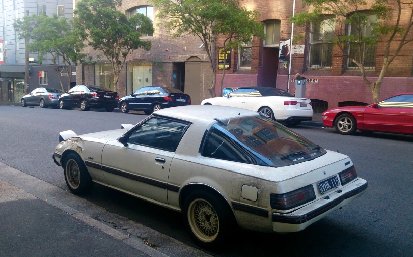 cars parked along a city street near a tall building