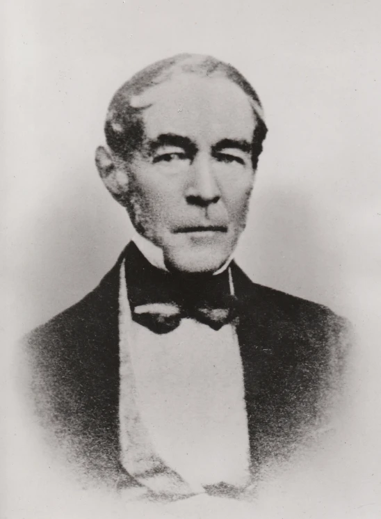 a black and white po of a man wearing a bow tie