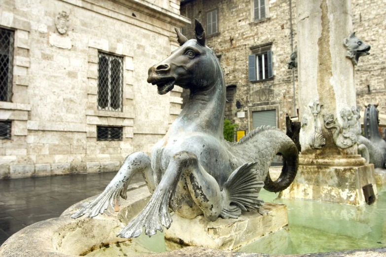 an artistic statue of a horse sitting on the side of a building