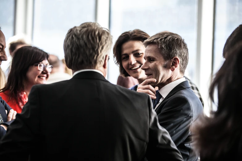 a group of people are standing together near windows