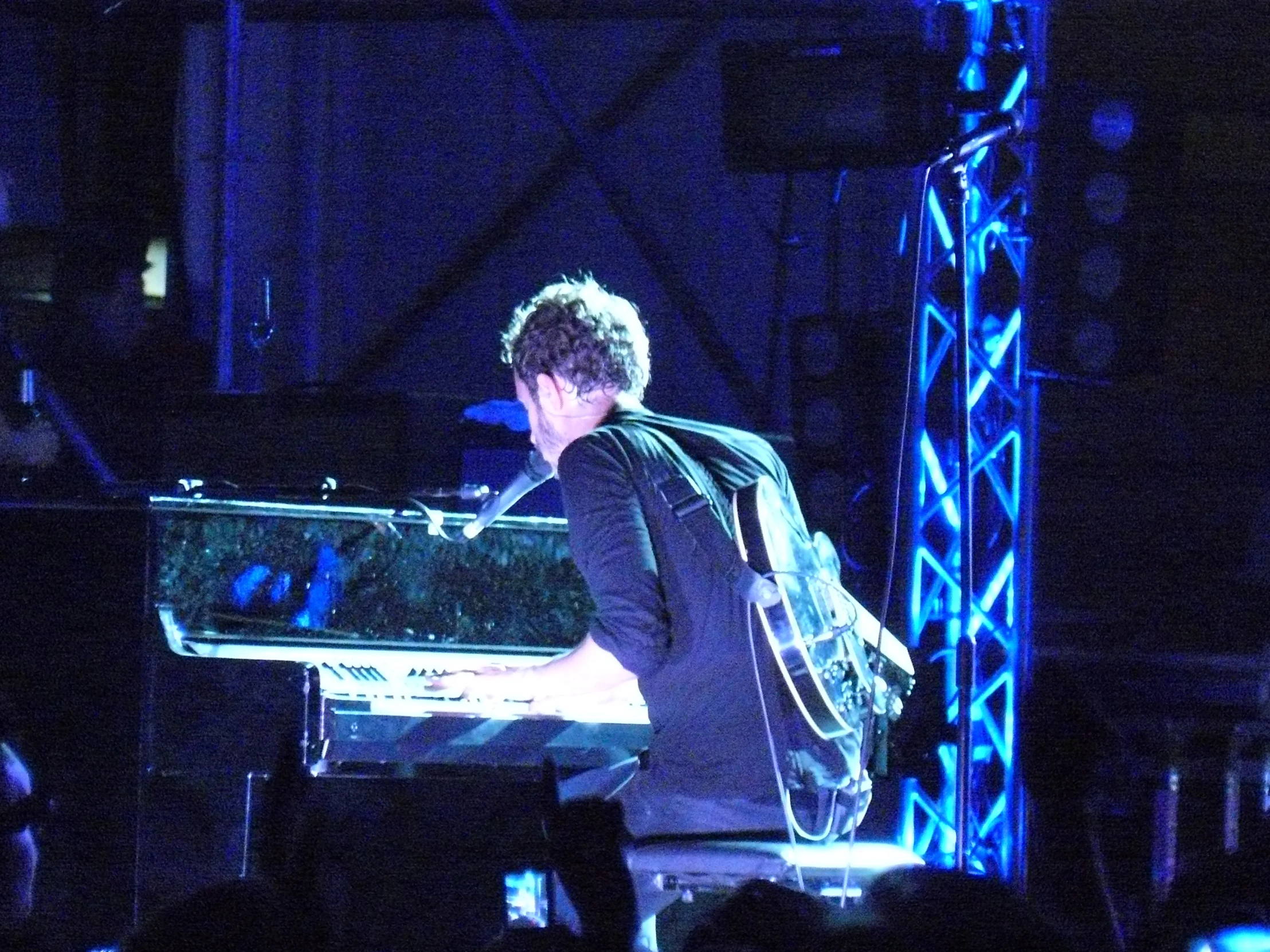 a man holding an electric guitar on stage