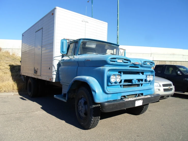 blue truck parked outside with large white box