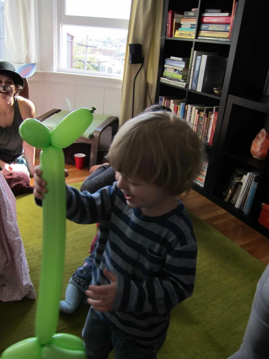 two children on a green carpet playing with a balloon