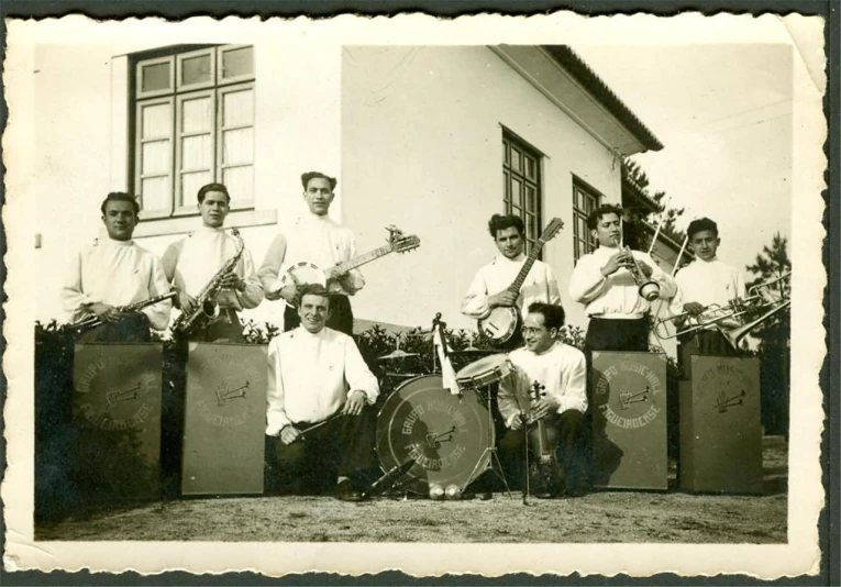 an old po of men posing for a picture with instruments