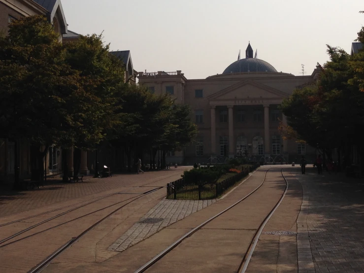 the railway tracks near a large building with a dome